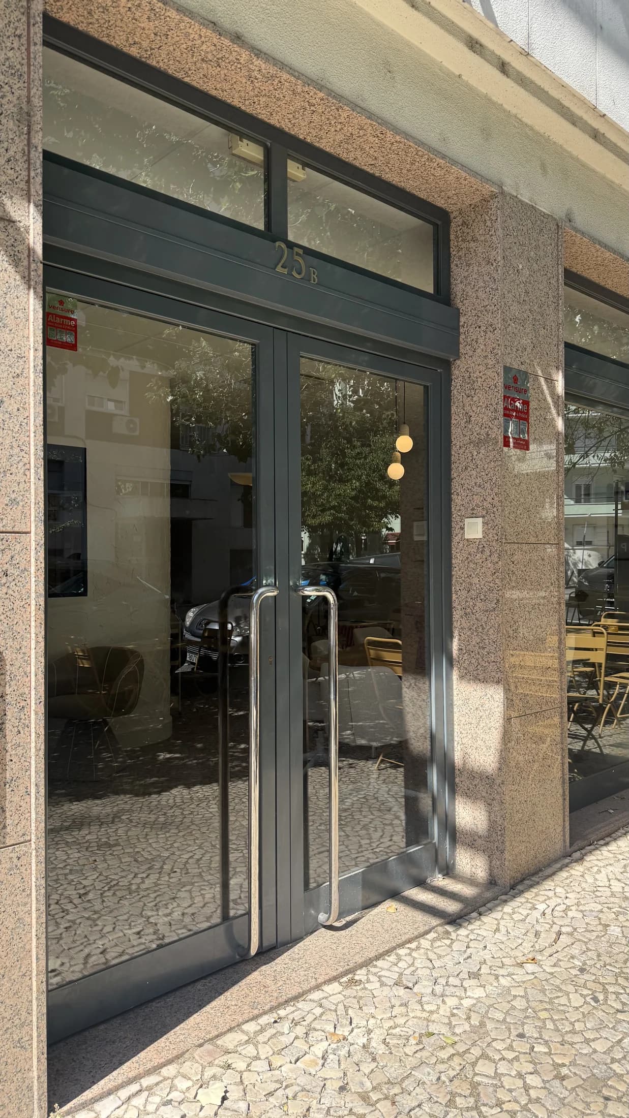 Portas de vidro da entrada do Elevada Club Cowork vistas do passeio